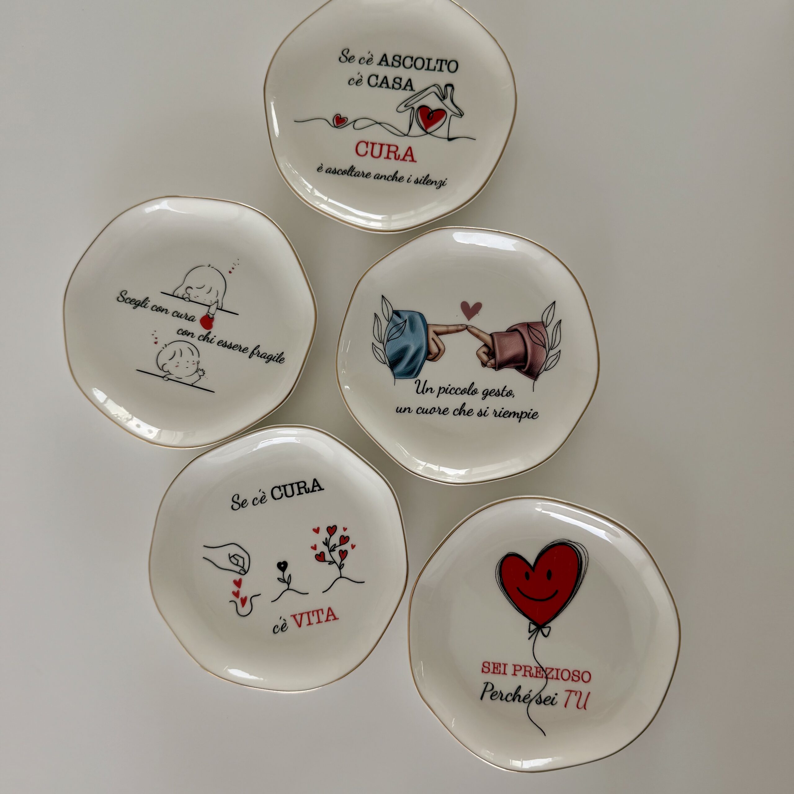 Composizione piatti svuotatasche ceramica personalizzati con diverse grafiche e frasi stampate UV
